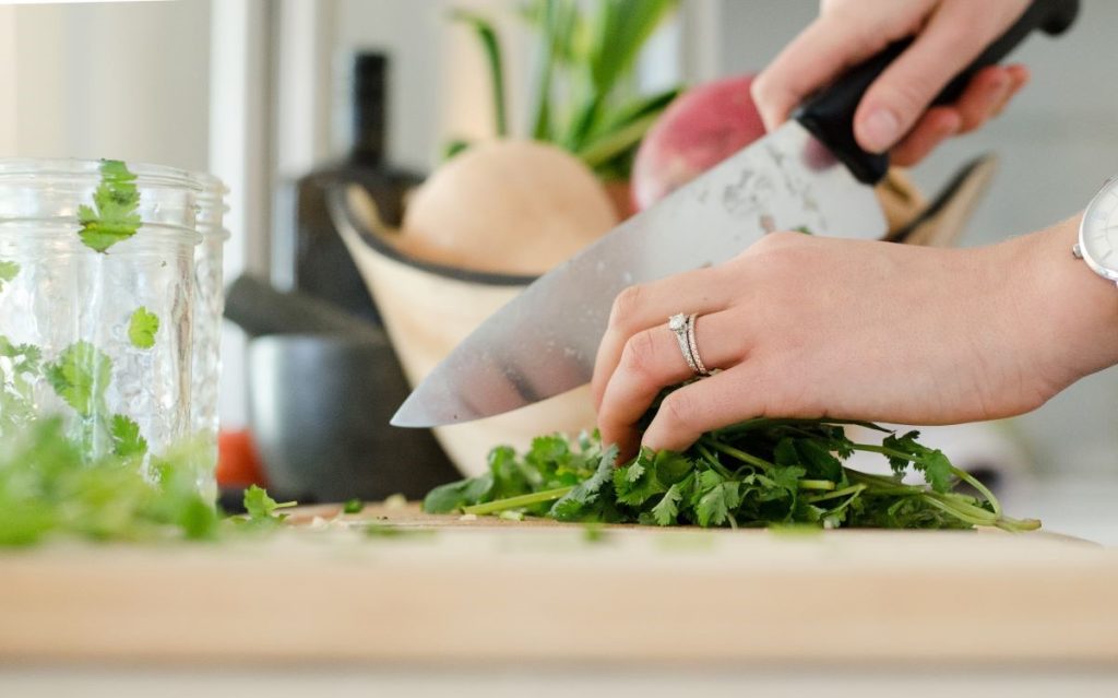 How to Be a Better Cook (Photo: Person cutting vegetables with knife)